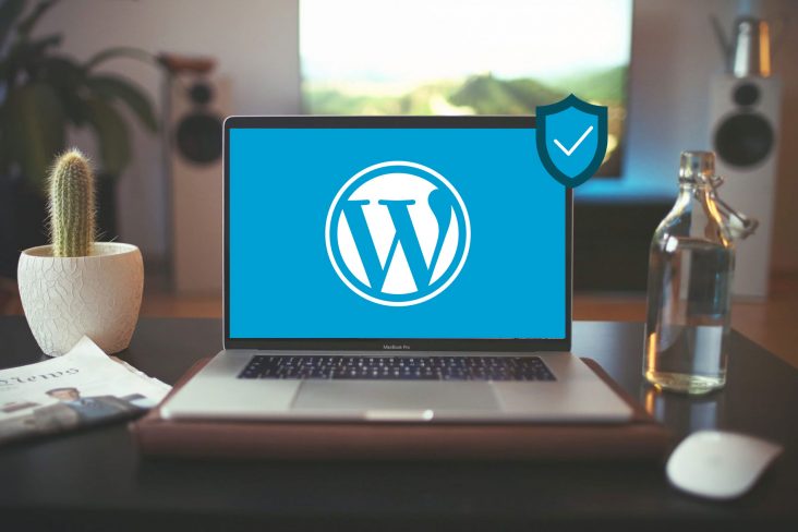 A laptop on a desk displaying a WordPress logo